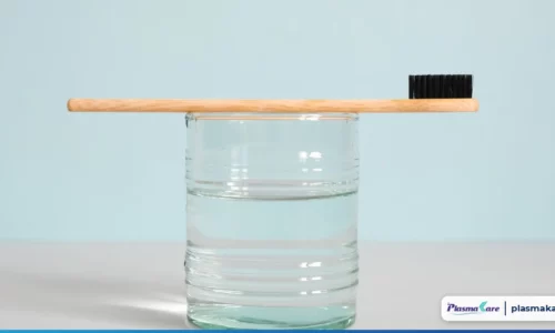 Bàn chải lông mềm đặt trên cốc nước, minh hoạ giữ sạch miệng khi bị nhiệt miệng